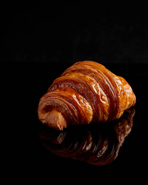 Traditional Croissant with reflection on black background